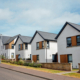 White render new-build detached homes with sandstone blockwork garden walls and timber cladding accents